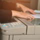 Women workers are using a copier in the office.